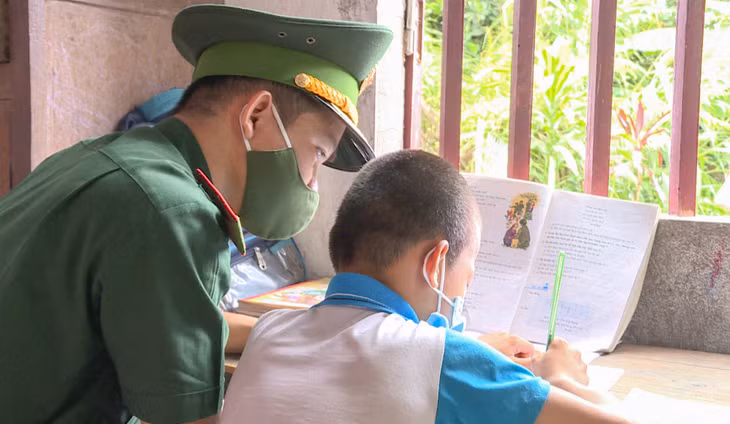 Cán bộ Đồn BPCK Hoành Mô dạy em Lý Gia Hưng học bài.