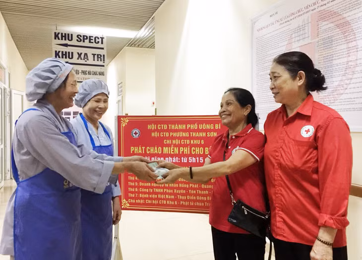 Bà Hảo (thứ 2, phải sang) nhận hỗ trợ thực hiện "Nồi cháo nhân đạo" từ các cá nhân, tổ chức hảo tâm. Ảnh năm 2019