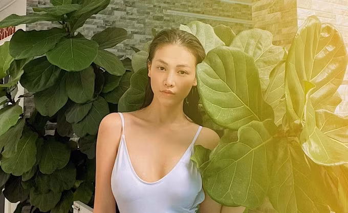 Người đẹp tạo dáng trong bộ swimwear và mốt tóc ướt trong một góc vườn.