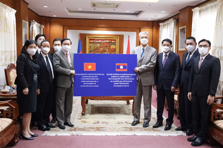 Đại sứ Nguyễn Bá Hùng (trái) đón nhận món quà của Thủ đô Vientiane, chiều 25-6.