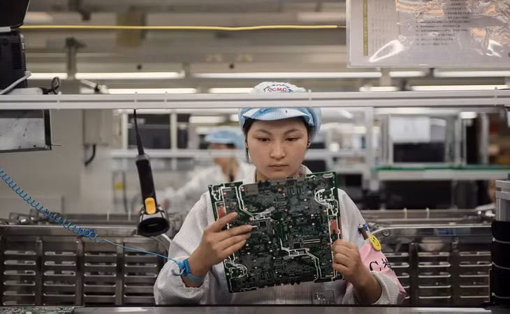 Một nhân viên kiểm tra linh kiện laptop HP tại Trùng Khánh, Trung Quốc. (Ảnh: NYT).