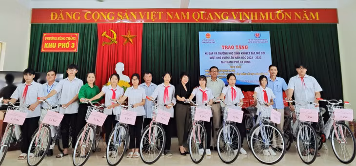 Lãnh đạo Hội Bảo trợ NKT-TMC cùng chính quyền địa phương và nhà tài trợ trao tặng xe đạp cho học sinh khuyết tật, mồ côi trên địa bàn phường Hùng Thắng (TP Hạ Long).