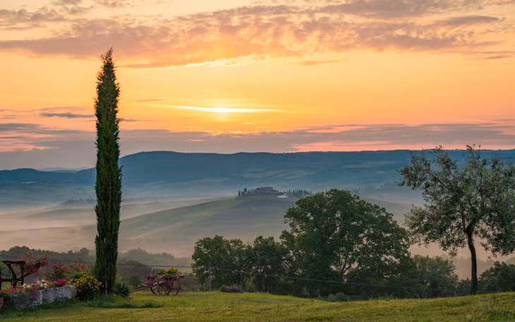 Ngôi làng San Quirico d'Orcia ở phía xa, đặc trưng cho những ngôi làng cổ nằm trên đồi cao, phía dưới tương phản là những đô thị mới hiện đại.