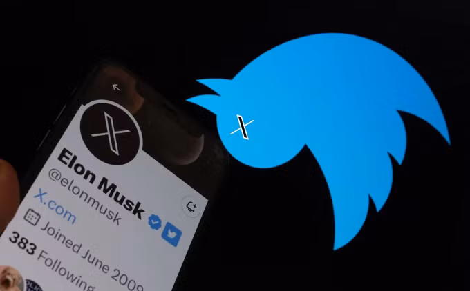 Logo chim xanh Twitter lộn ngược bên cạnh tài khoản Elon Musk hiển thị trên smartphone. Ảnh: AFP