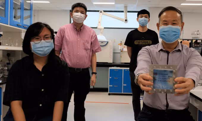 Nhóm nghiên cứu tại Đại học Công nghệ Nanyang với mẫu kính cửa sổ kết hợp vật liệu mới. Ảnh: NTU Singapore