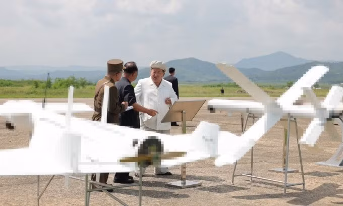 Ông Kim Jong-un bên cạnh hai mẫu UAV tự sát trong chuyến thăm hôm 24/8. Ảnh: KCNA