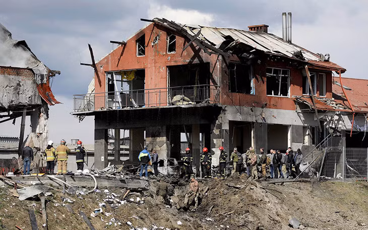 Quân nhân và lực lượng cứu hộ Ukraine có mặt tại hiện trường ngôi nhà tại TP Ukraine bị phá hủy, ngày 18/4. (Ảnh: Reuters)