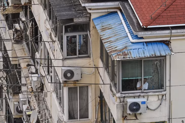 Người đàn ông nhìn ra bên ngoài từ cửa sổ trong đợt phong toả do COVID-19 ở Thượng Hải hôm 12/4. Ảnh: AFP