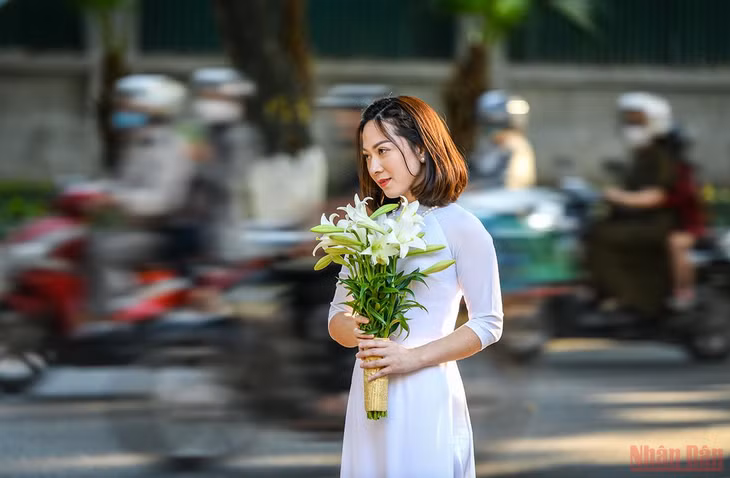 Những người yêu hoa ưu ái chọn cho mình chiếc áo dài trắng để lưu lại khoảnh khắc nên thơ của Thủ đô trong mùa loa kèn. (Ảnh: THÀNH ĐẠT)