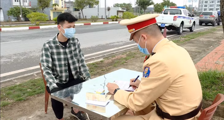 Cán bộ Đội CSGT số 2, Phòng CSGT đường bộ, đường sắt (Công an tỉnh) lập biên bản xử phạt người vi phạm luật giao thông trên QL18 đoạn đi qua địa bàn TP Cẩm Phả.