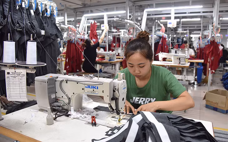 Công nhân Công ty cổ phần Nam Tiệp (Cụm công nghiệp An Xá, thành phố Nam Ðịnh) may quần áo xuất khẩu. (Ảnh NAM ANH)