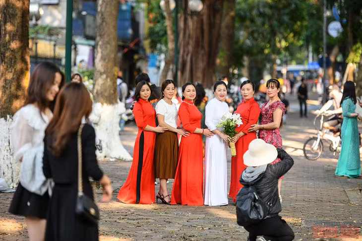Những ngày cuối tuần, trên phố Phan Đình Phùng, khá đông người đến lưu lại khoảnh khắc đẹp trong mùa loa kèn. (Ảnh: THÀNH ĐẠT)