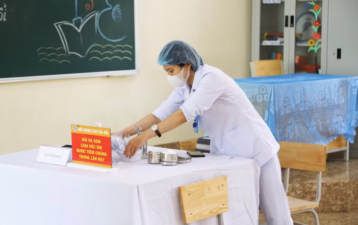 Cán bộ, nhân viên y tế kiểm tra dụng cụ tiêm, đảm bảo mọi điều kiện an toàn cho việc tiêm vắc xin.
