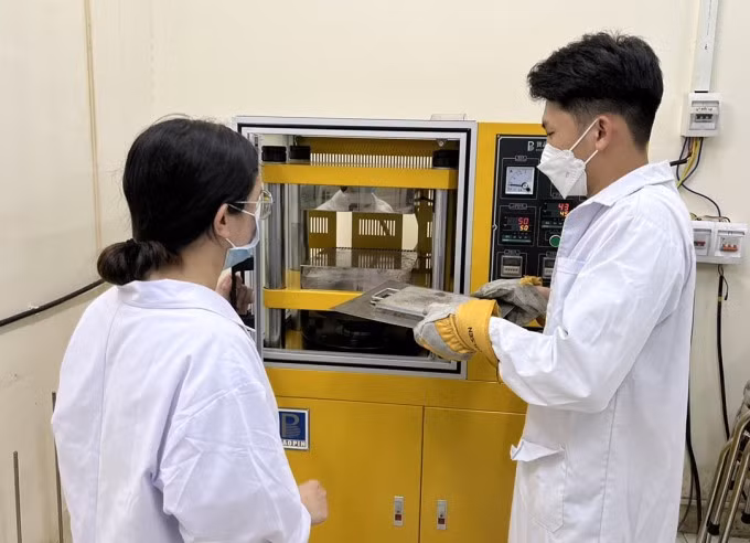 Nhóm thực hiện công đoạn ép nhiệt để tạo tấm nhựa PP trong phòng thí nghiệm. Ảnh: NVCC