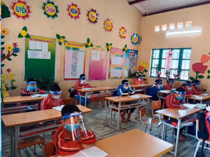 Học sinh Trường Tiểu học Đạp Thanh (huyện Ba Chẽ) đeo khẩu trang, tấm chắn giọt bắn khi ngồi trong lớp học (Ảnh chụp ngày 4/4).