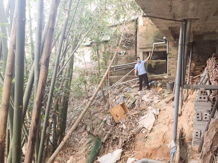 Nước lũ làm cho móng nhà ông Đinh Tiến Bàng chênh vênh bên bờ sông.