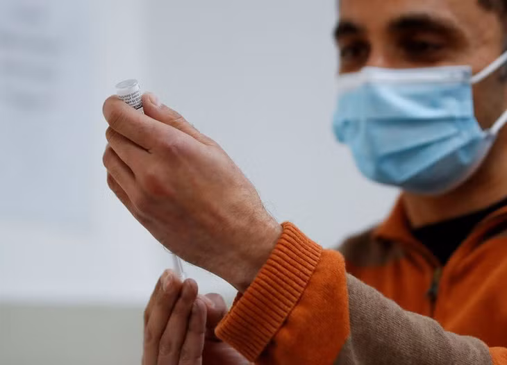 Nhân viên y tế chuẩn bị vaccine Covid-19 tại Anh hôm 21/10. Ảnh: Reuters.