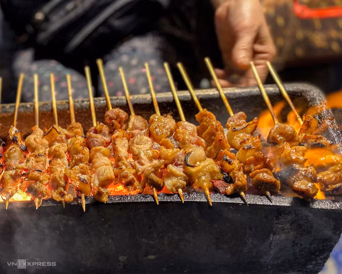 Thịt xiên nướngLà món quà chiều dễ gây nghiện với giới trẻ, thịt xiên nướng có sức hút cũng nhờ giá rẻ, phần ăn vừa phải, thịt lại đủ mỡ nạc tẩm ướp để không quá ngấy. Mỗi khi nướng xong lớp thịt bóng mỡ, xém xém vài góc được người bán đem ngay ra cho khách ăn kèm với bánh mì nóng hoặc dưa chuột, rau củ muối... Muốn ăn thịt xiên nướng ngon, bạn hãy ghé qua các phố Hàm Long, Khâm Thiên, Quang Trung, chợ Nghĩa Tân, Trấn Vũ... Ảnh: Trung Nghĩa