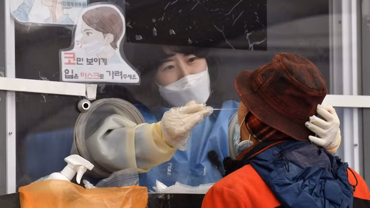 Nhân viên y tế lấy mẫu xét nghiệm tại Seoul ngày 1/12. Ảnh: AFP.