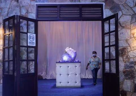 Một người phụ nữ đi ngang qua viên sapphire xanh corundum tự nhiên lớn nhất thế giới, nặng 310 kg, được tìm thấy trong một hố đá quý, tại một tư gia ở Horana, Sri Lanka, ngày 12/12/2021. Ảnh: REUTERS