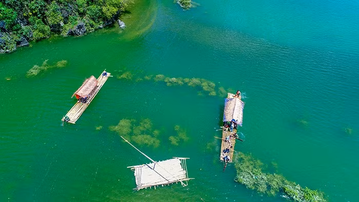 Du khách tham quan hồ Đồng Lâm trên những chiếc bè được người dân địa phương sử dụng hằng ngày