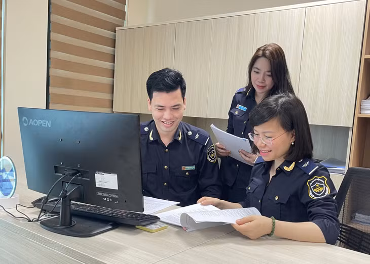 Anh Hoàng Minh Tuấn trao đổi công việc cùng đồng nghiệp.