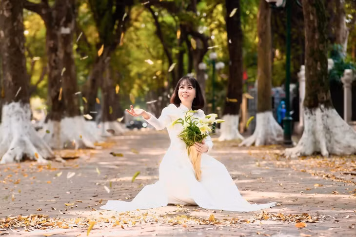 Nét đẹp dịu dàng của người con gái Hà Thành bên bó hoa loa kèn trắng tinh khôi trên tuyến phố Phan Đình Phùng.