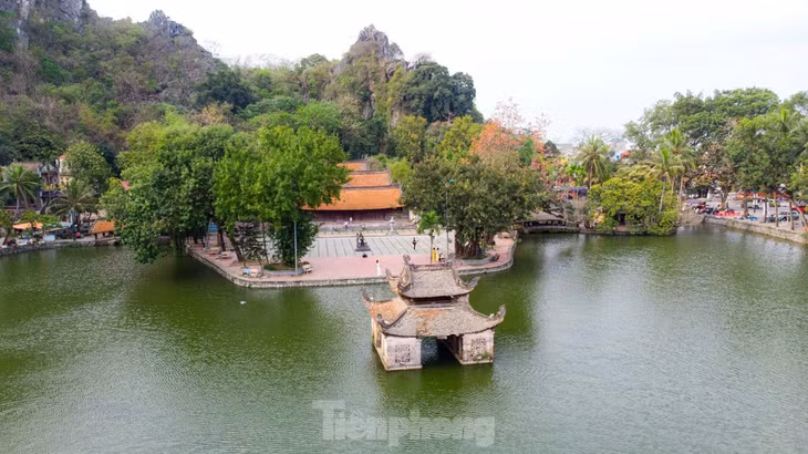 Màu hoa nở đỏ rực trên nền núi trập trùng tạo nên một khung cảnh tĩnh mịch, cổ kính của chùa Thầy.