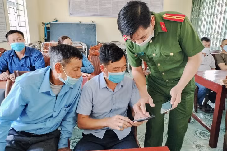 Người dân xã Quảng Phong (huyện Hải Hà) được hướng dẫn cài đặt, sử dụng ứng dụng báo cháy 114 trên điện thoại thông minh. Ảnh: Công an huyện Hải Hà
