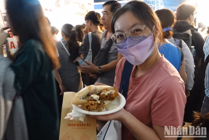Một bạn trẻ vui mừng khi mua được ổ bánh mì cua.