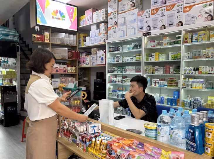 Khách hàng thanh toán bằng hình thức quét mã QR tại Chợ Trung tâm Tiên Yên (huyện Tiên Yên).)