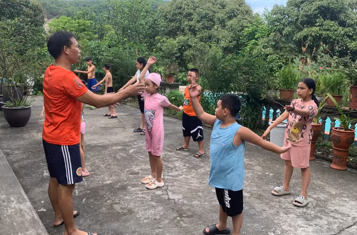 Giáo viên hướng dẫn học sinh một số động tác vận động trước khi bơi tại phường Cẩm Thịnh, TP Cẩm Phả.