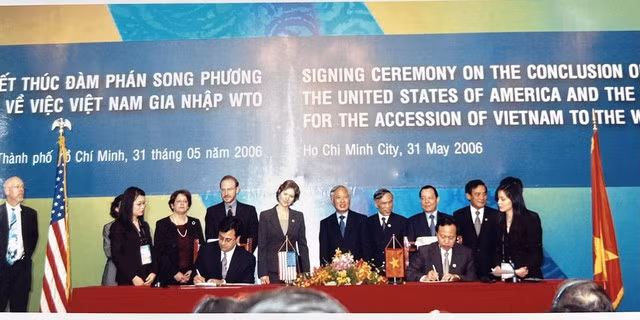 Lễ ký hiệp định gia nhập WTO song phương với Hoa Kỳ (Phó Thủ tướng Vũ Khoan đứng thứ 5 từ phải sang trái, Thứ trưởng Lương Văn Tự ký hiệp định) - Ảnh: VGP/NN