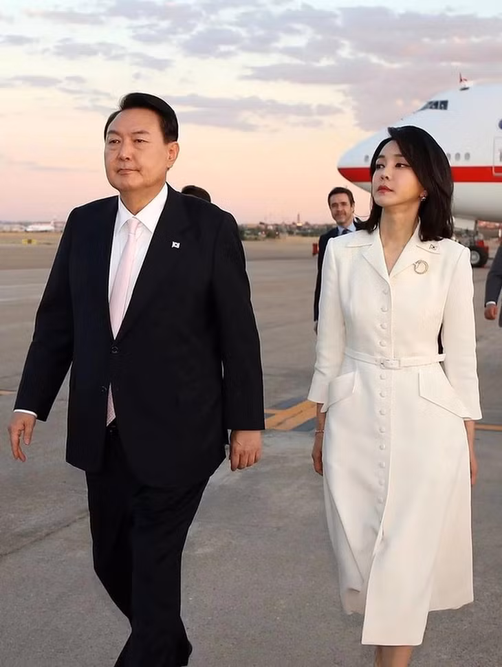 Trong lần sang châu Âu dự hội nghị NATO, bà Kim Keon Hee được dân mạng Hàn Quốc khen thanh lịch, sang trọng với mẫu đầm trắng trơn, đính khuy dọc thân áo. Theo Naver, Đệ nhất Phu nhân Hàn Quốc tích cực lăng-xê thương hiệu thời trang trong nước mỗi lần công du. Mẫu áo đến từ hãng nội địa Avouavou cũng nhanh chóng bán hết.