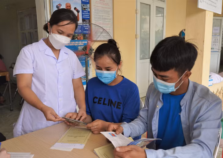 Cán bộ dân số Trạm Y tế phường Hải Yên (TP Móng Cái) tư vấn cho cặp vợ chồng thực hiện sàng lọc trước sinh và sơ sinh để sinh được em bé khỏe mạnh. Ảnh: Hoài Minh
