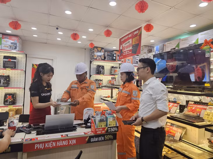 Cán bộ Điện lực TP Cẩm Phả tuyên truyền việc sử dụng tiết kiện điện đối với các hộ kinh doanh thương mại, dịch vụ.