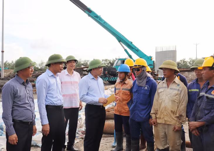 Bí thư Tỉnh ủy Nguyễn Xuân Ký trò chuyện, động viên công nhân thi công cầu Tổ hợp (Km3+600) thuộc dự án Đường ven sông kết nối từ cao tốc Hạ Long - Hải Phòng đến TX Đông Triều. Ảnh: Thu Chung