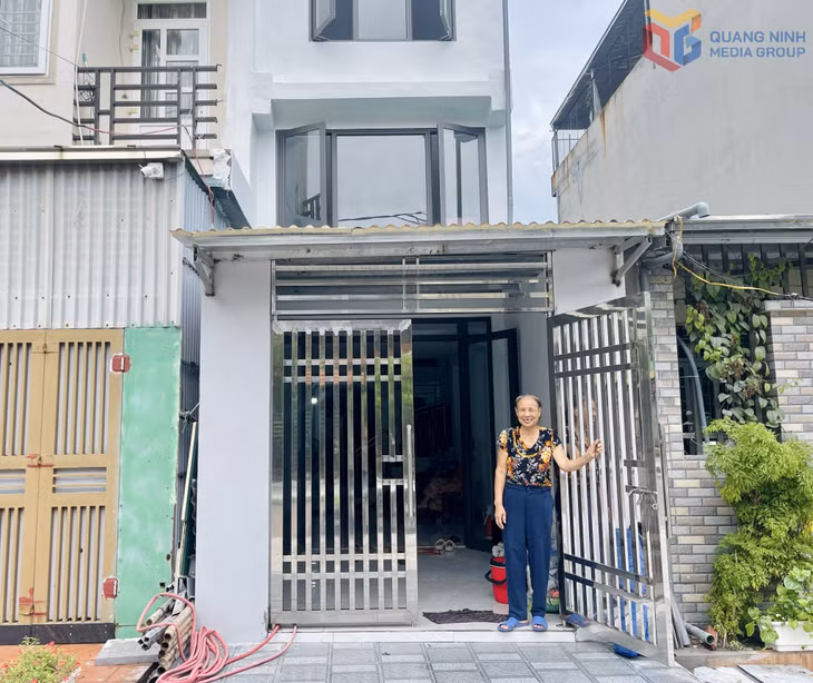 Bà Nguyễn Thị Thi và ngôi nhà phía sau đã được sửa sang lại.