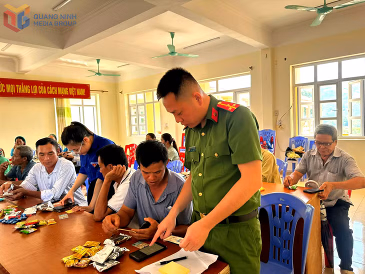 Cán bộ Công an xã Đông Ngũ hướng dẫn người dân tộc thiểu số tích hợp giấy tờ vào VNeID.