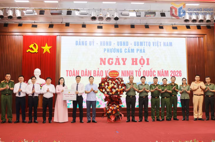 Đại tá Vũ Thanh Tùng, Phó Bí thư Đảng ủy, Phó Giám đốc Công an tỉnh, tặng hoa chúc mừng tại Ngày hội toàn dân bảo vệ ANTQ phường Cẩm Phả năm 2026.