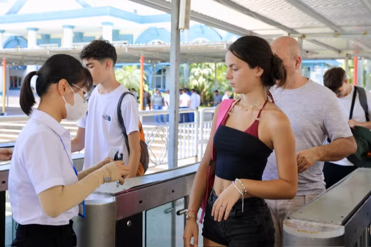 Du khách nước ngoài làm thủ tục xuống tàu tham quan vịnh.