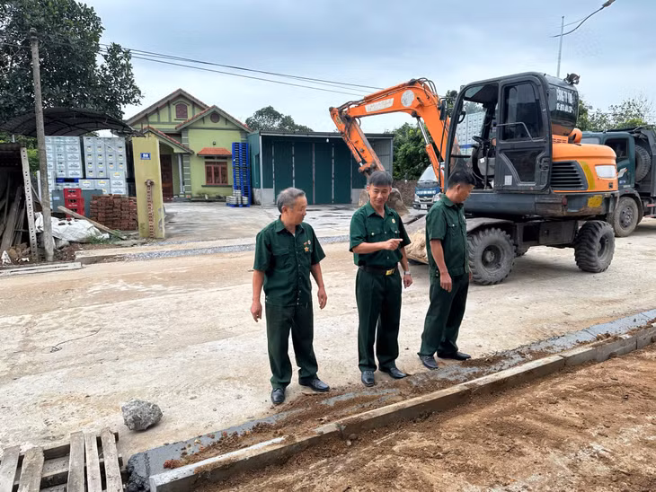 Bí thư Chi bộ, Trưởng thôn Hải Sơn (xã Quảng Đức) Lại Văn Cường (đứng giữa) kiểm tra chất lượng, tiến độ công trình đường thôn.