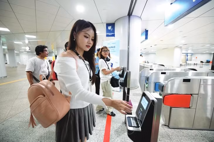 Người dân đã thuận lợi hơn khi trải nghiệm những ứng dụng của chuyển đổi số trong các sinh hoạt hằng ngày. Trong ảnh: Các bạn trẻ thanh toán không tiền mặt tại metro - Ảnh: QUANG ĐỊNH