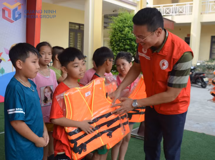 Cán bộ Hội Chữ thập đỏ tỉnh Quảng Ninh trao tặng áo phao cho các em có hoàn cảnh gia đình khó khăn tại xã Liên Hoà.