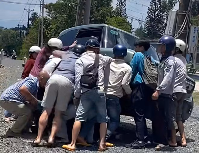 Khoảnh khắc người dân hợp sức nâng ô tô cứu nữ sinh bị tông mắc kẹt dưới gầm. Ảnh: Hoài Thanh