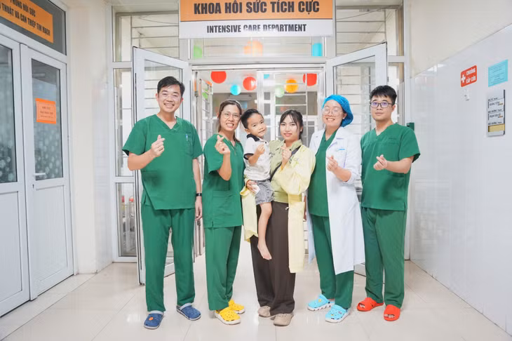 Các y, bác sĩ Bệnh viện Sản Nhi Quảng Ninh chúc mừng bệnh nhi mắc tay chân miệng khỏi bệnh và xuất viện.
