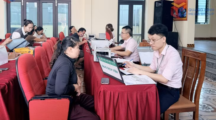 Cán bộ Phòng Giao dịch Ngân hàng CSXH phường Yên Tử giải ngân cho hội viên nông dân vay vốn. Ảnh: Cao Quỳnh
