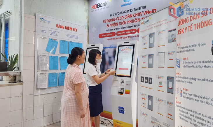 Nhân viên công tác xã hội Bệnh viện Bãi Cháy hướng dẫn người dân đăng ký khám bệnh trên hệ thống kiosk thông minh, kết nối với hệ thống bệnh án điện tử của bệnh viện.
