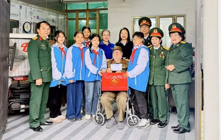 Chị Trần Thị Thu Hương (thứ 5, phải sang) cùng học sinh đến thăm, tặng quà thương binh nhân dịp kỷ niệm Ngày thành lập Quân đội Nhân dân Việt Nam 22/12 (1944-2025).