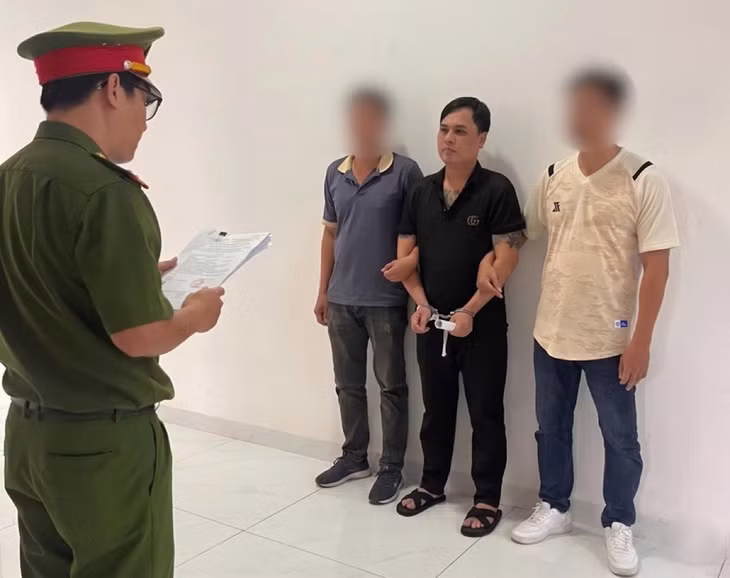 Công an đọc lệnh bắt tạm giam bị can sau khi triệt phá đường dây môi giới mại dâm trực tuyến. Ảnh: Công an
